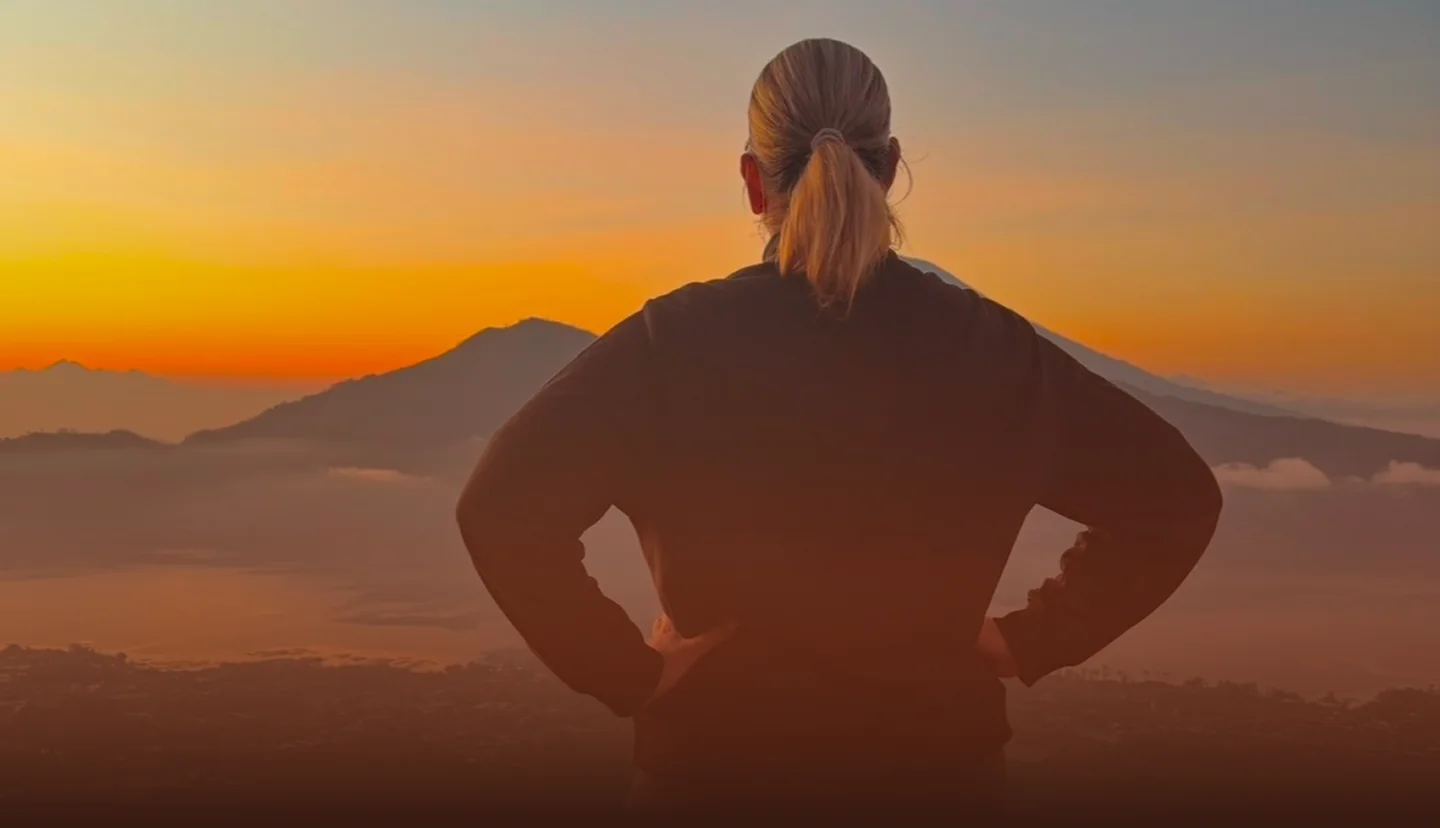 A woman looking over mountains at sunrise